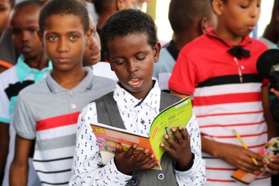 A group of children read from interactive lesson books in their Sabbath School. 