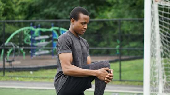 A man stretching during physical exercise. He is living out Ellen White's counsel on healthy living and exercise.