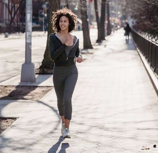 A young woman jogging outside.
