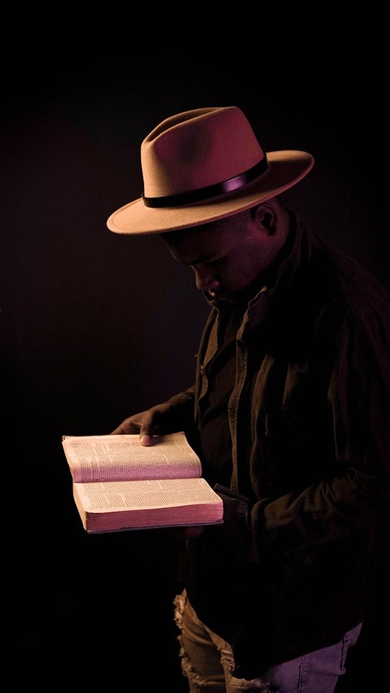 A smiling man holds the Bible open to read and study its messages.