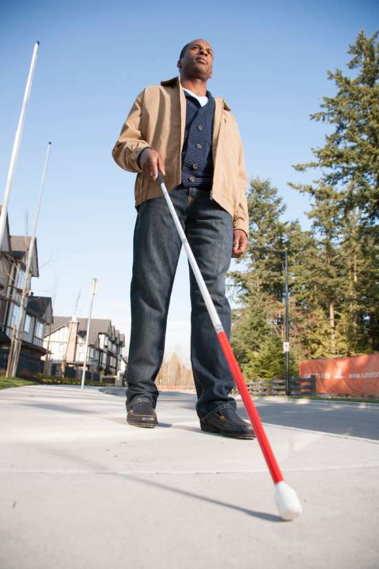 A blind man walking with a cane
