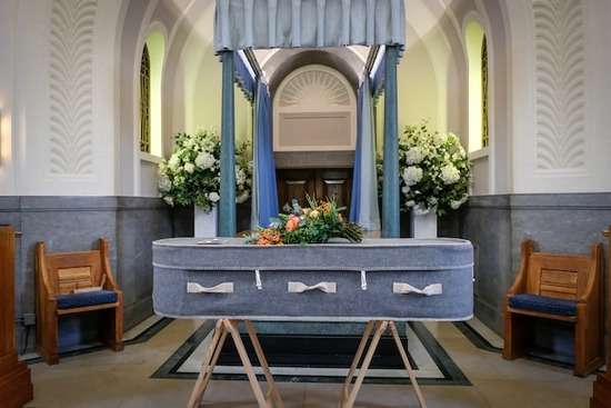 A funeral at a church with a casket resting in the front