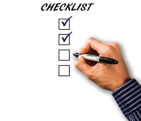 A hand checking off boxes in a checklist, something that the Adventist fundamental beliefs are not