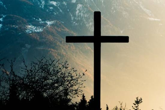 A cross with the mountains in the background