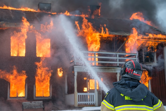 A firefighter spraying water on a burning house, a loss of a possession