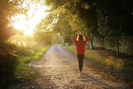 A woman walking outdoors to get the health benefits of sunlight