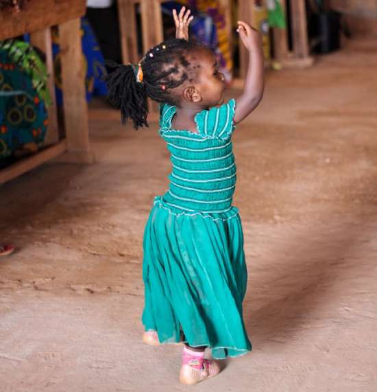 A little girl celebrating the Sabbath in church by dancing to the worship music