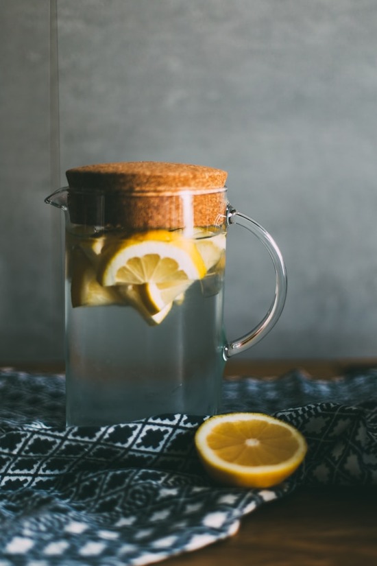 A pitcher of fresh, clean water with lemon slices floating in it. This is a tasty, healthy way to quench thirst and stay hydrated.