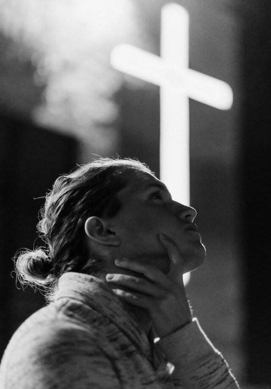 A woman looking at the Cross and considering Jesus Christ and His sacrifice for her