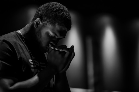 A man prays alone showing his faith in God