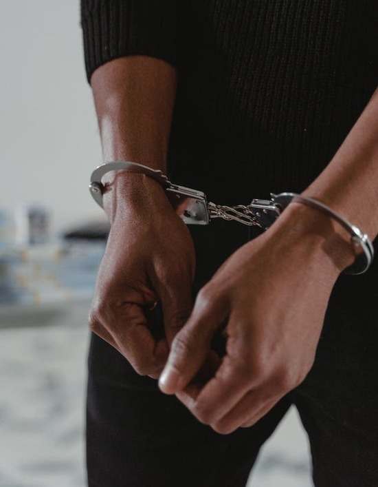 A zoomed-in photo of hands in handcuffs
