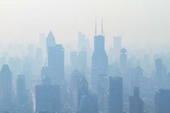 High-rise buildings in a city surrounded by smog and polluted air