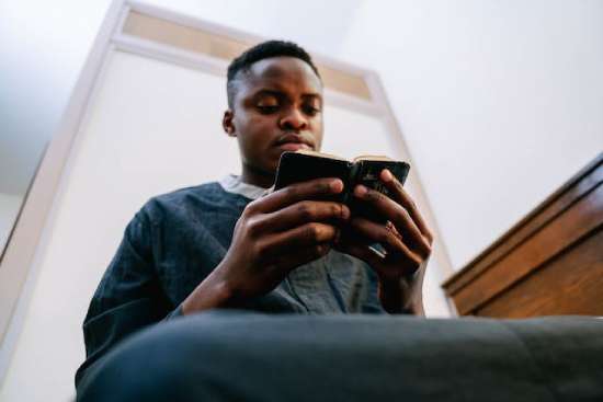 A teenage young man sits and reads a Bible